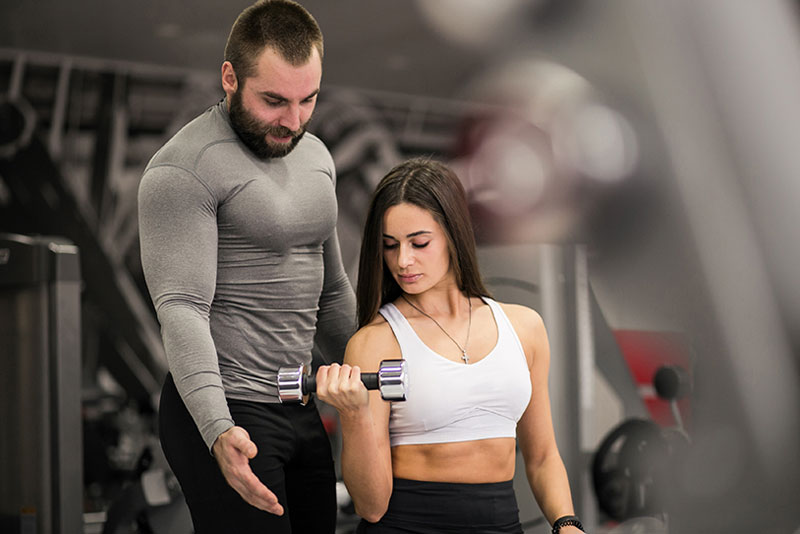 Trainer Helping in Biceps Exercise