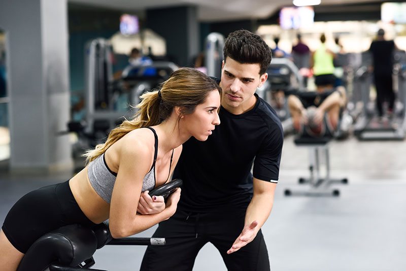 Trainer Helping in Back Exercise